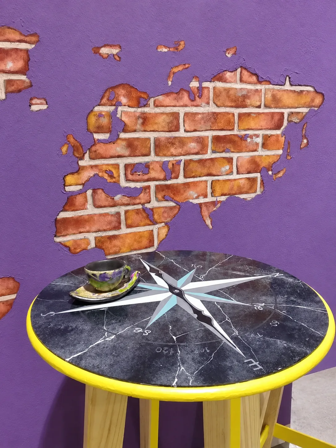 Ambientación de arte decorativo con pared de falsos ladrillos y mesa con imitación de mármol