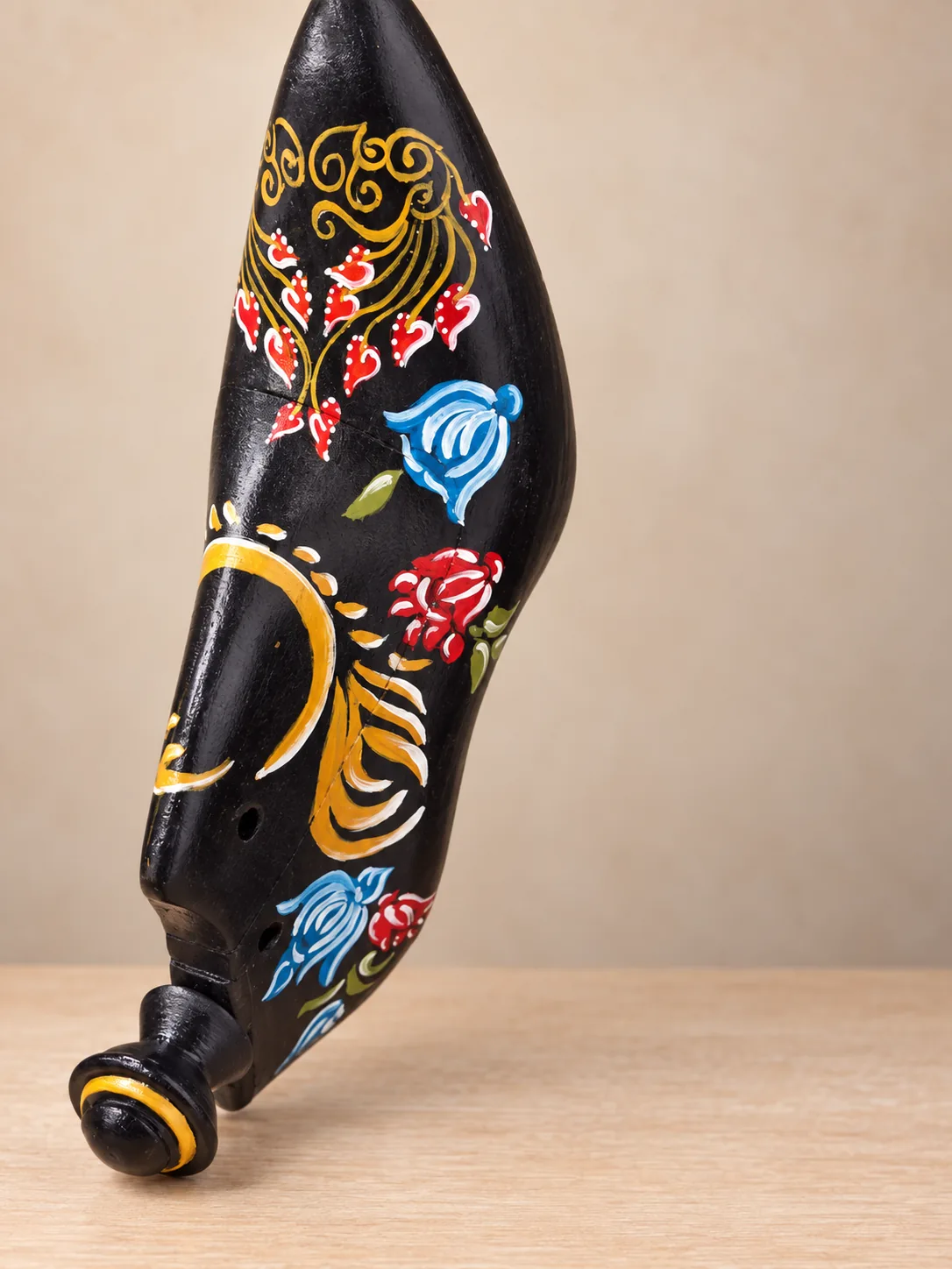 Horma de madera negra decorada con motivos florales en técnica Zhostovo