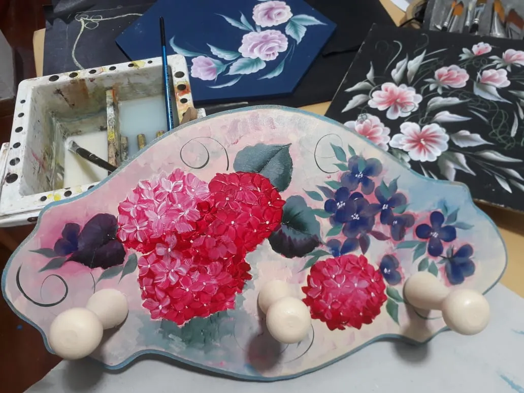 Perchero pintado con hortensias rosas y flores violetas