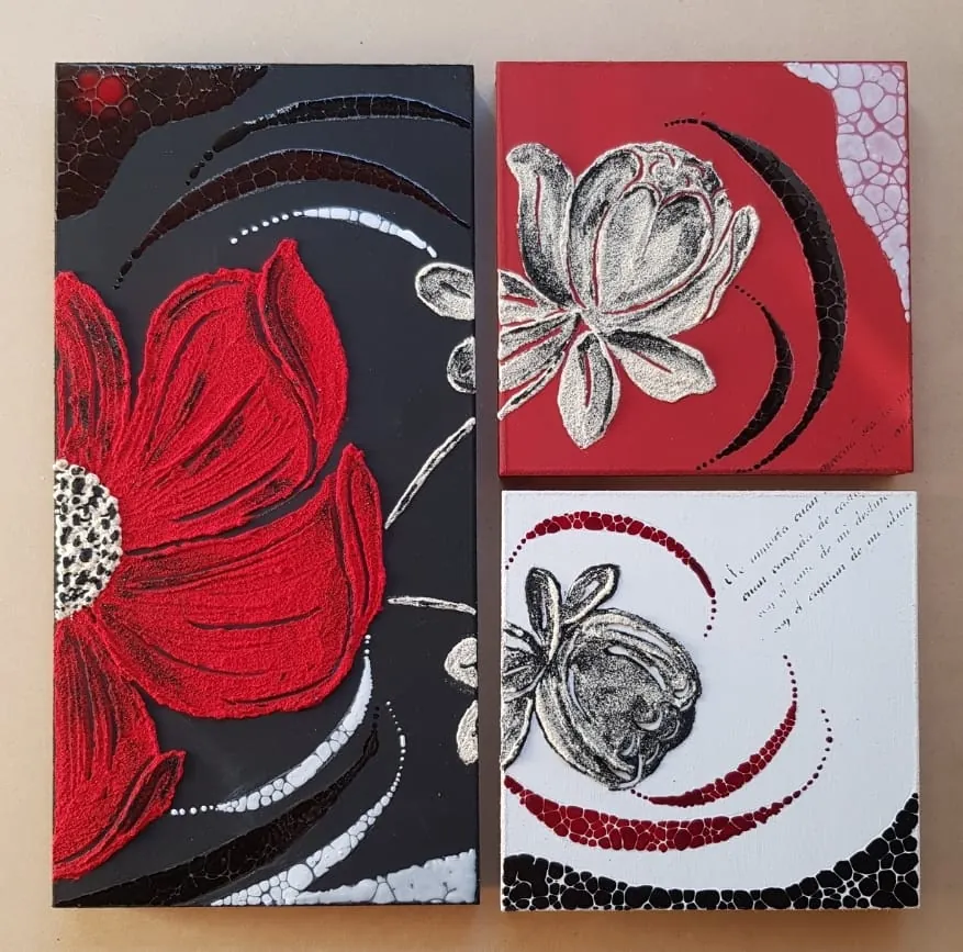 Tres paneles con flores rojas y blancas sobre fondos negro y rojo