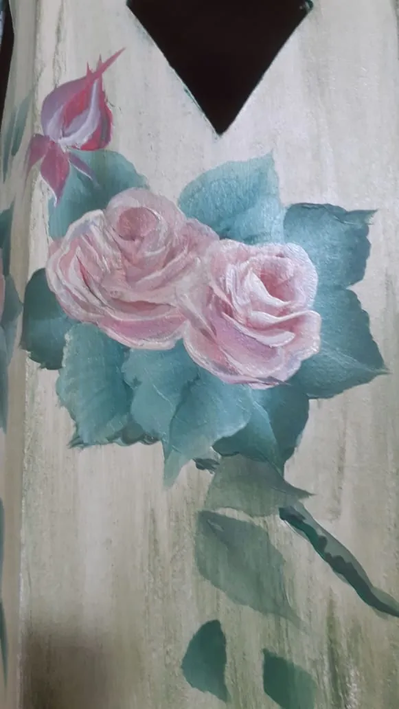 Detalle de rosas rosadas y hojas verdes pintadas sobre madera clara
